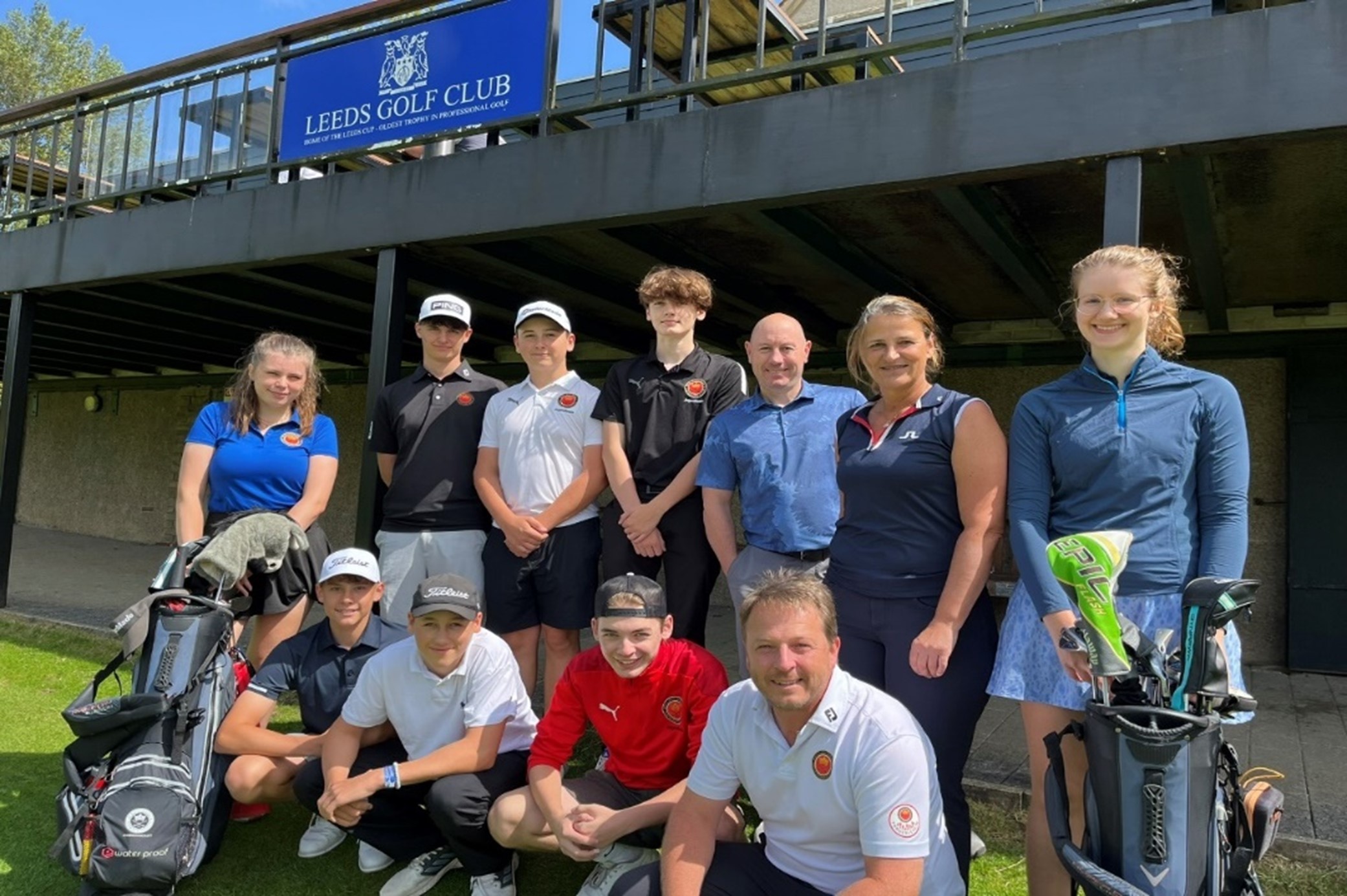 11 Golfer und Golferinnen stehen vor dem Clubhaus in Leeds