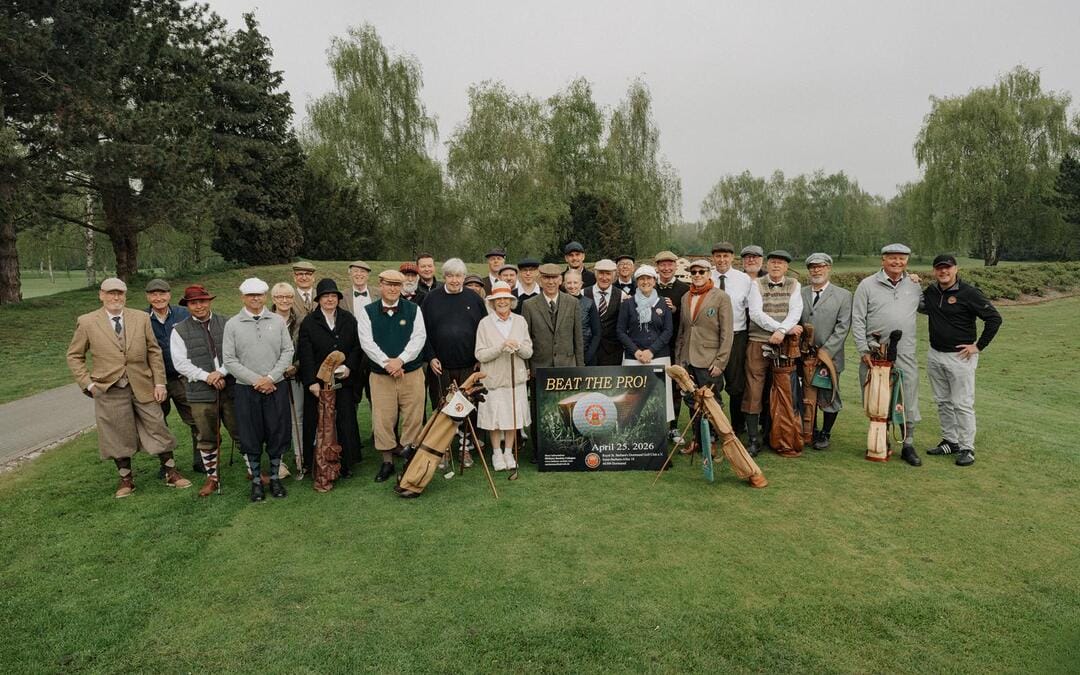 Viele ältere Menschen stehen auf einem Golfplatz zusammen und posieren für ein Gruppenfoto bei einer Veranstaltung namens "BEAT THE PRO!" am 25. April 2026.